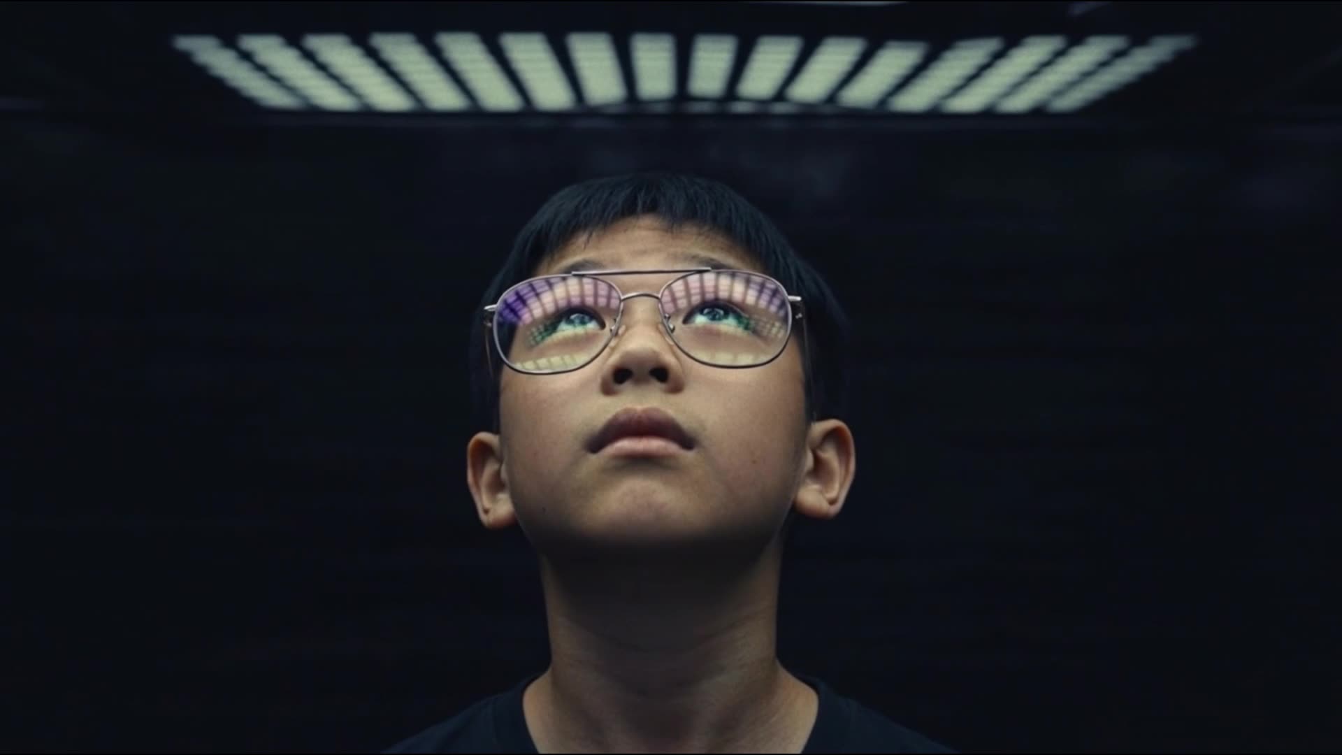 A boy in glasses, data reflected in the lenses